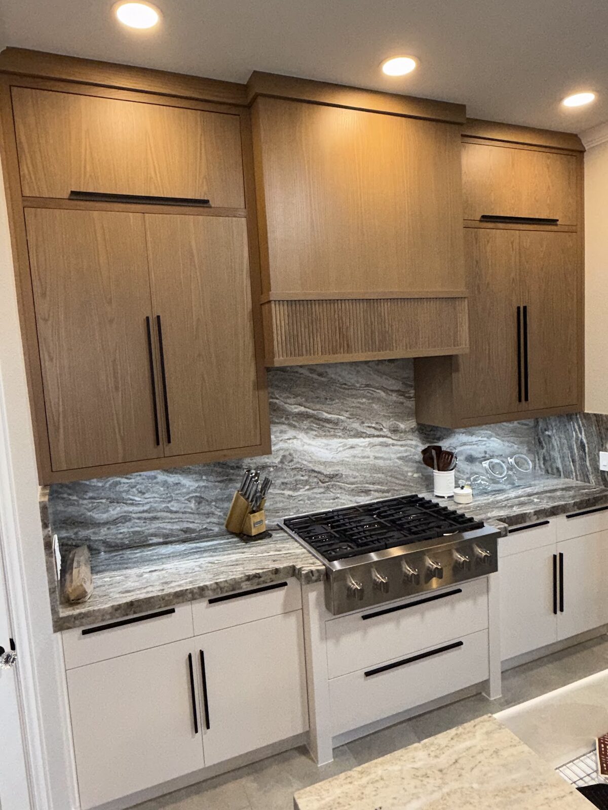 Custom oak kitchen cabinets with stone backsplash by Urbina Cabinet